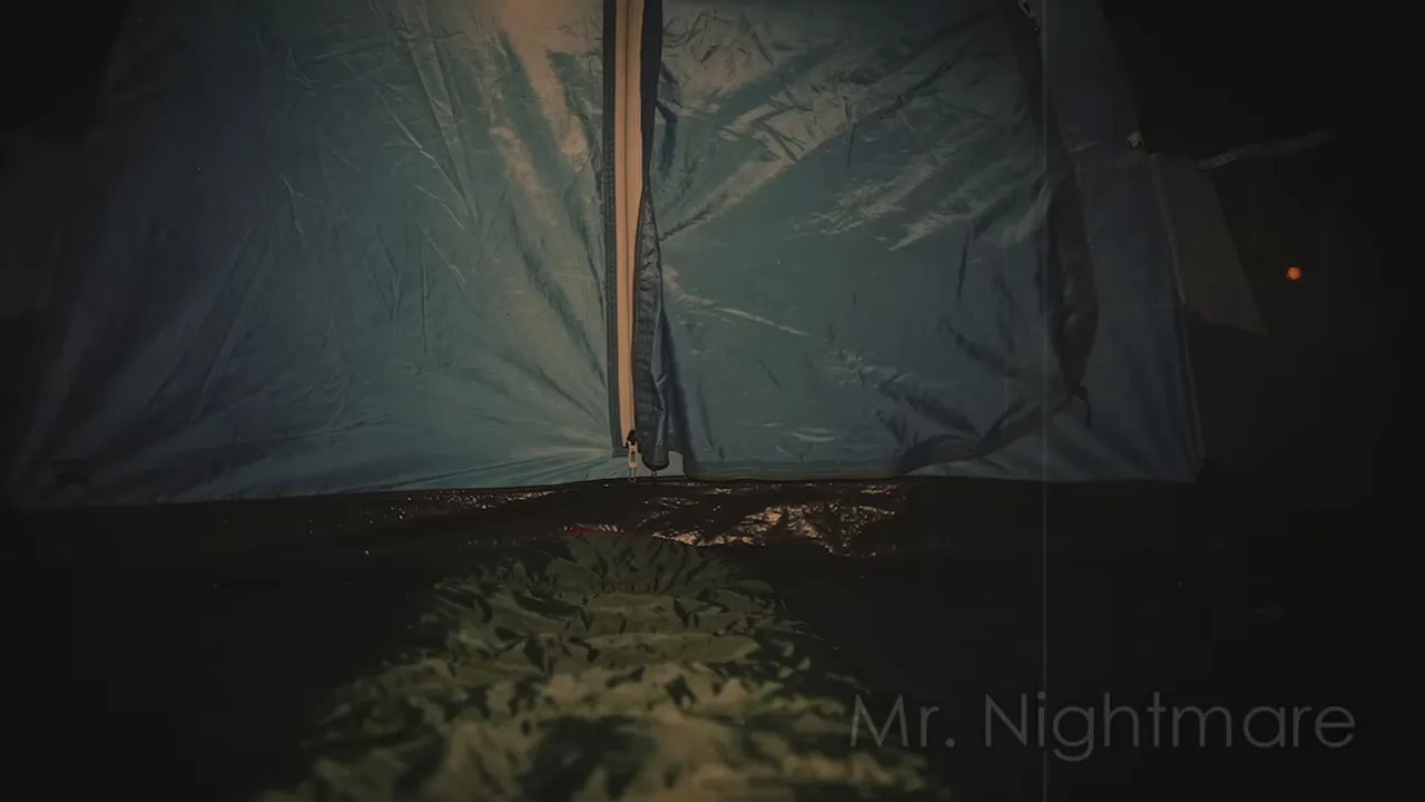 Close view of a tent door opening in a dark campsite during night in the deep woods
