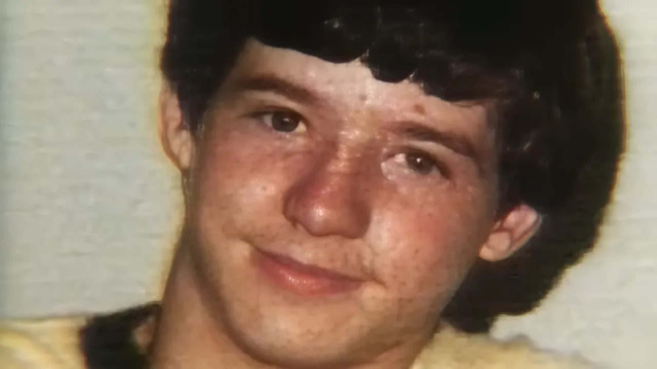 Close-up archival portrait of a teenage boy smiling, head-and-shoulders