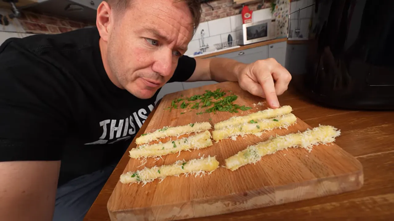 Rows of rolled breadsticks coated in garlic butter and Parmesan beside an air fryer