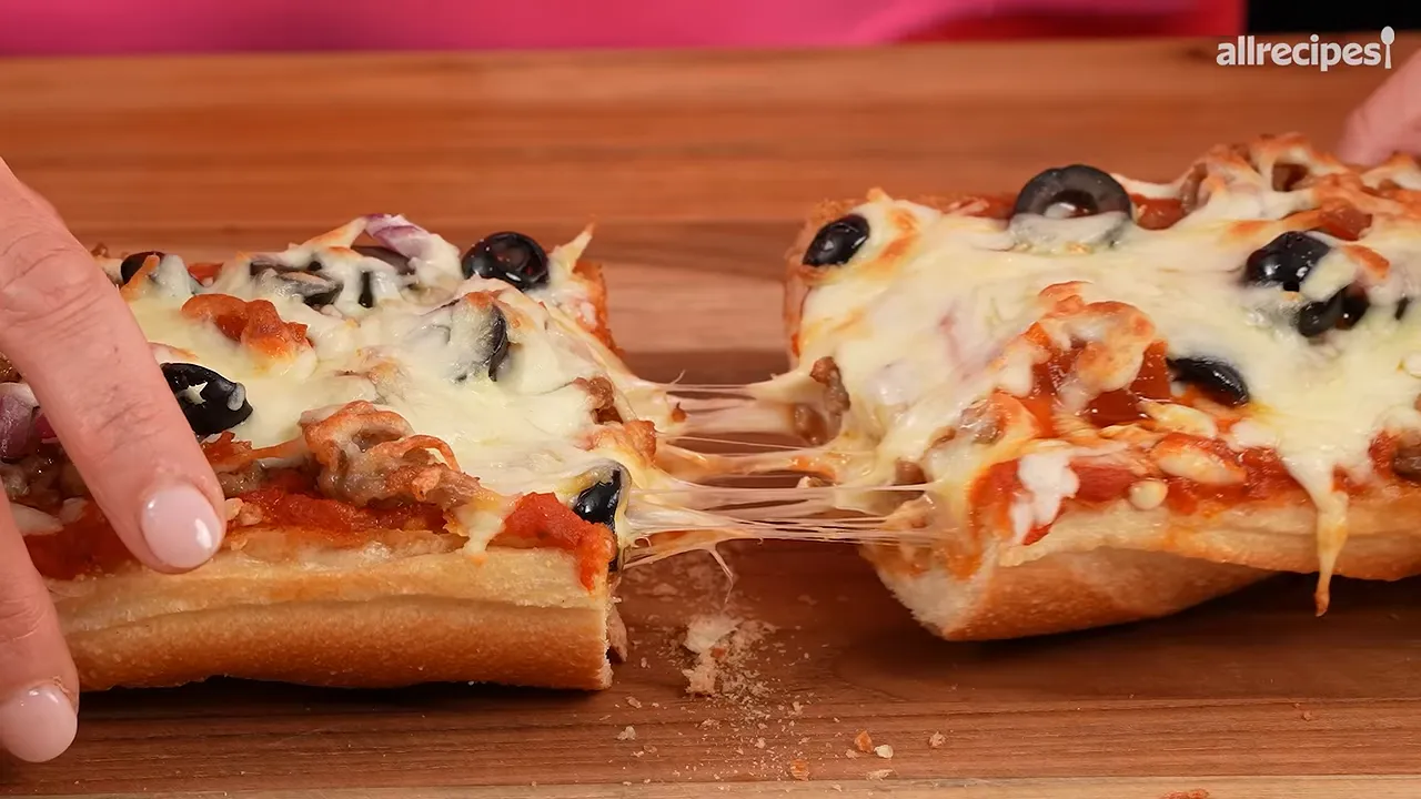 French bread pizza piece lifted from a sliced loaf with melted cheese stretching