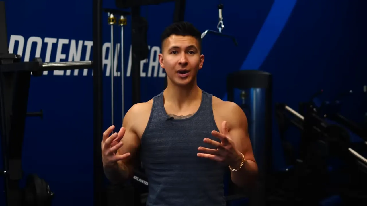 Presenter speaking in a gym environment explaining training principles