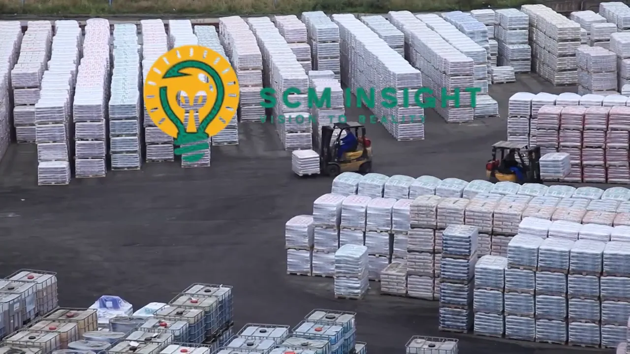 Kho hàng ngoài trời với nhiều kiện hàng và xe nâng hoạt động