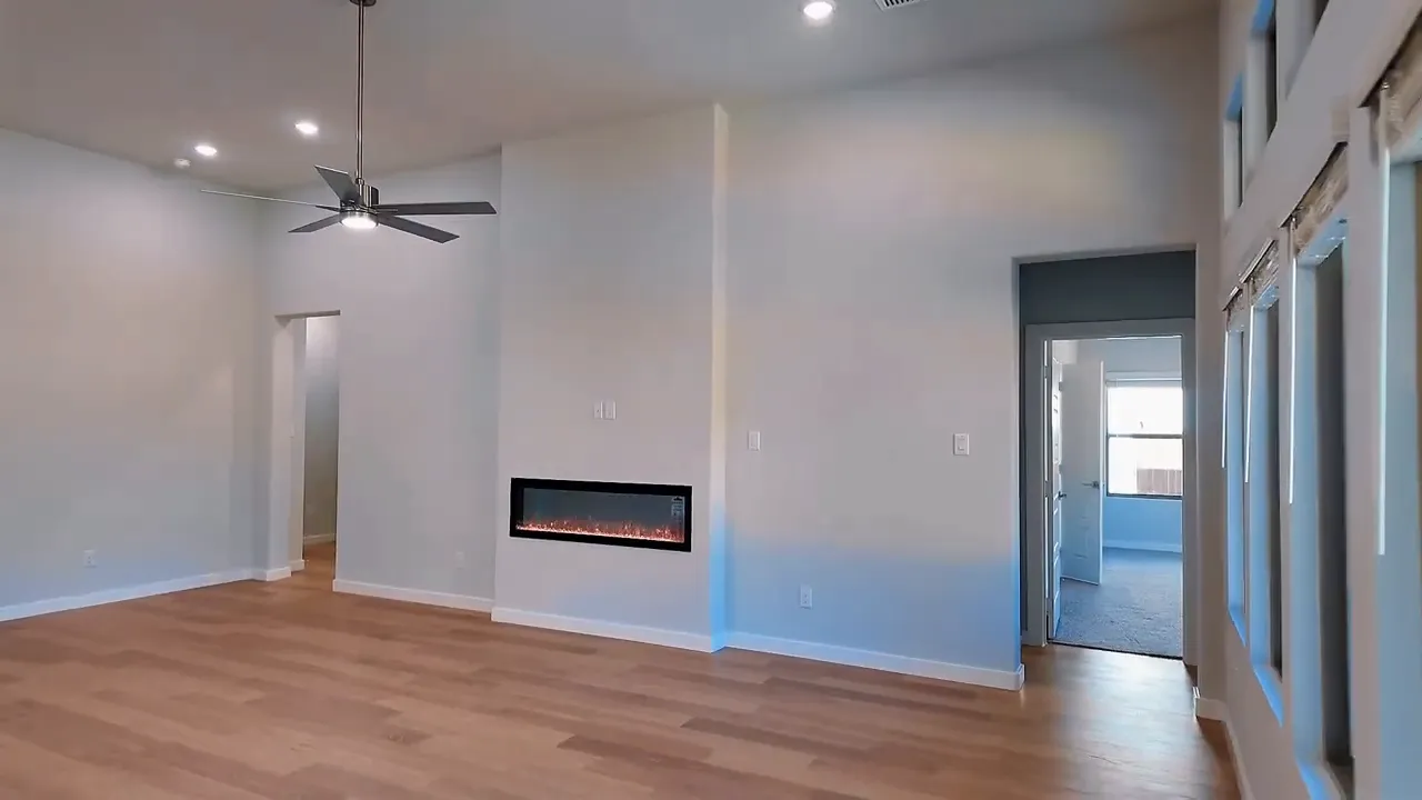 Spacious living room with fireplace and ceiling fan in a new construction home