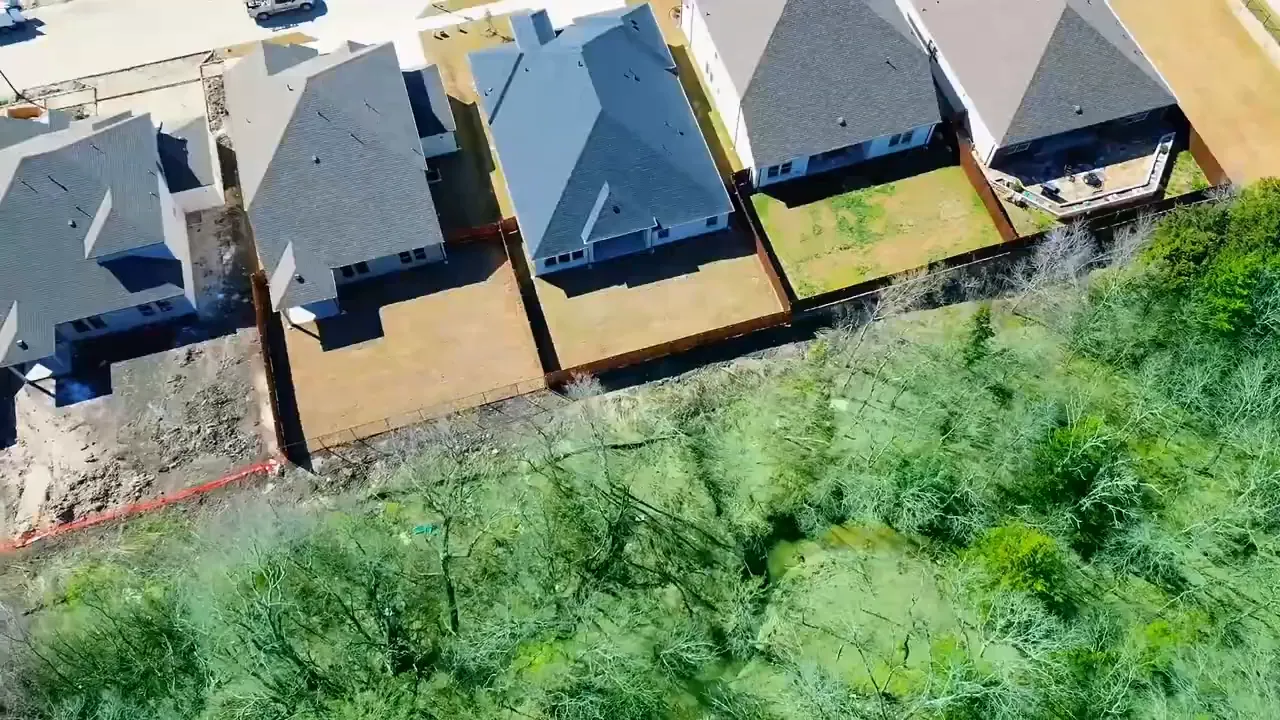 Aerial view of new construction homes and lots near green vegetation in Princeton, Texas