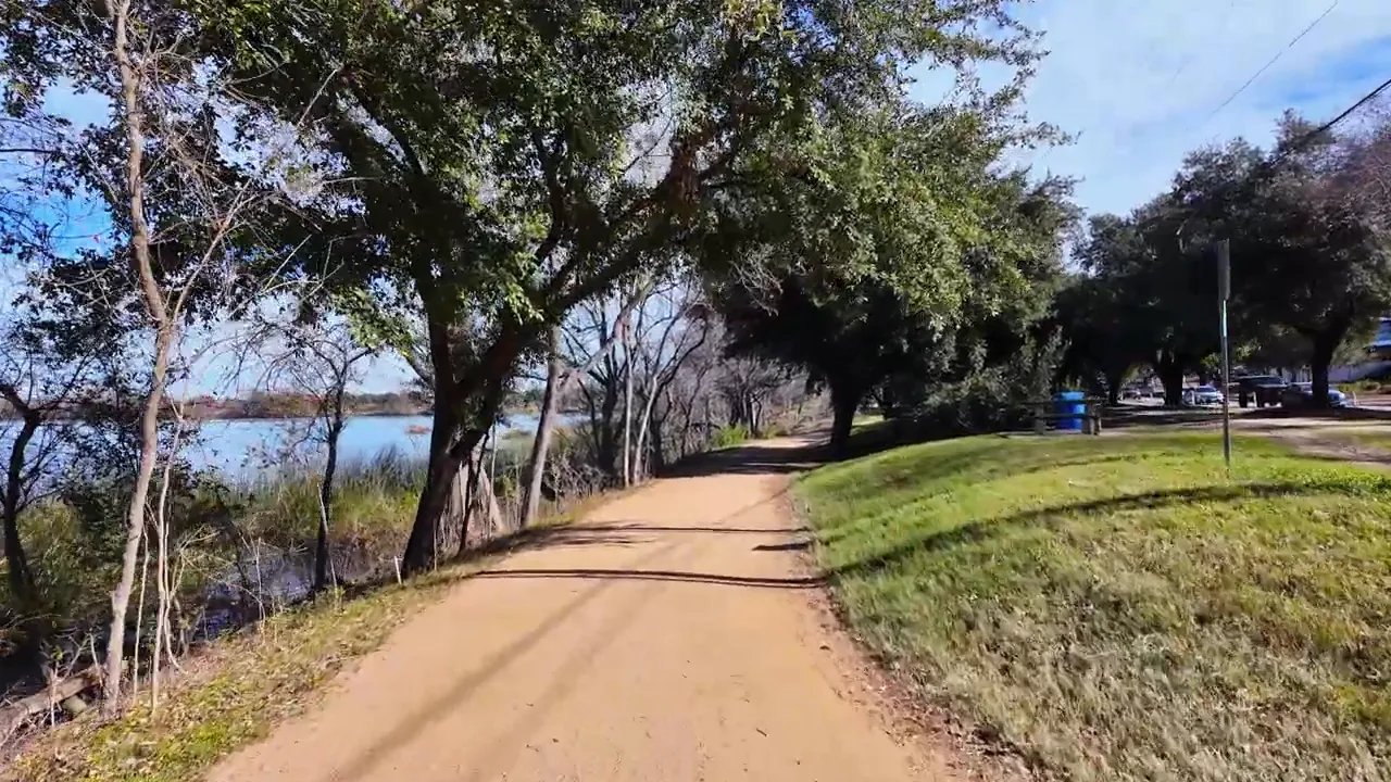 Scenic walking trail beside a lake with trees in Austin