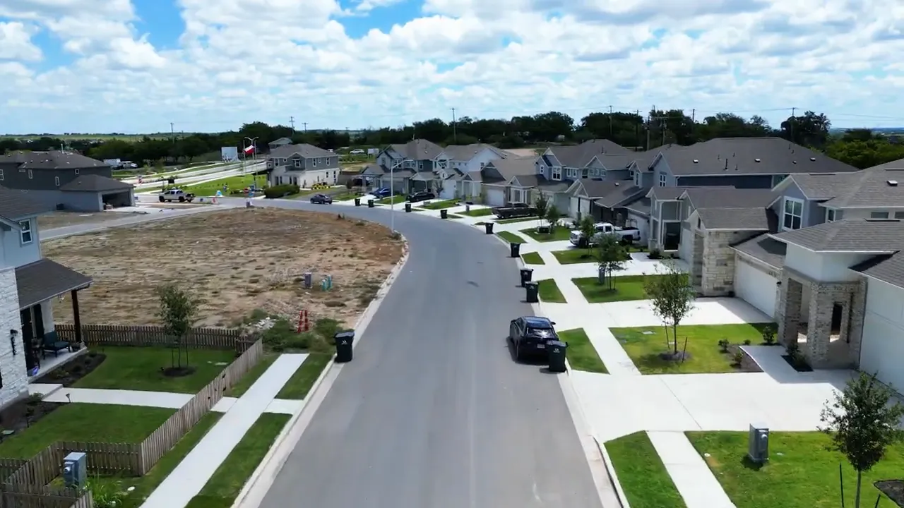 Aerial view of a new construction neighborhood with modern homes and planned lots in Buda TX