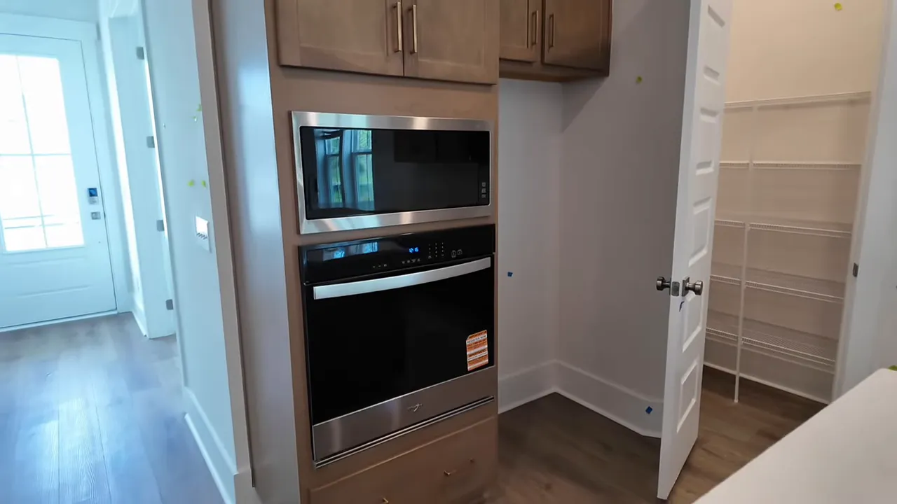 Open kitchen with L-shaped island wood cabinets and white countertops