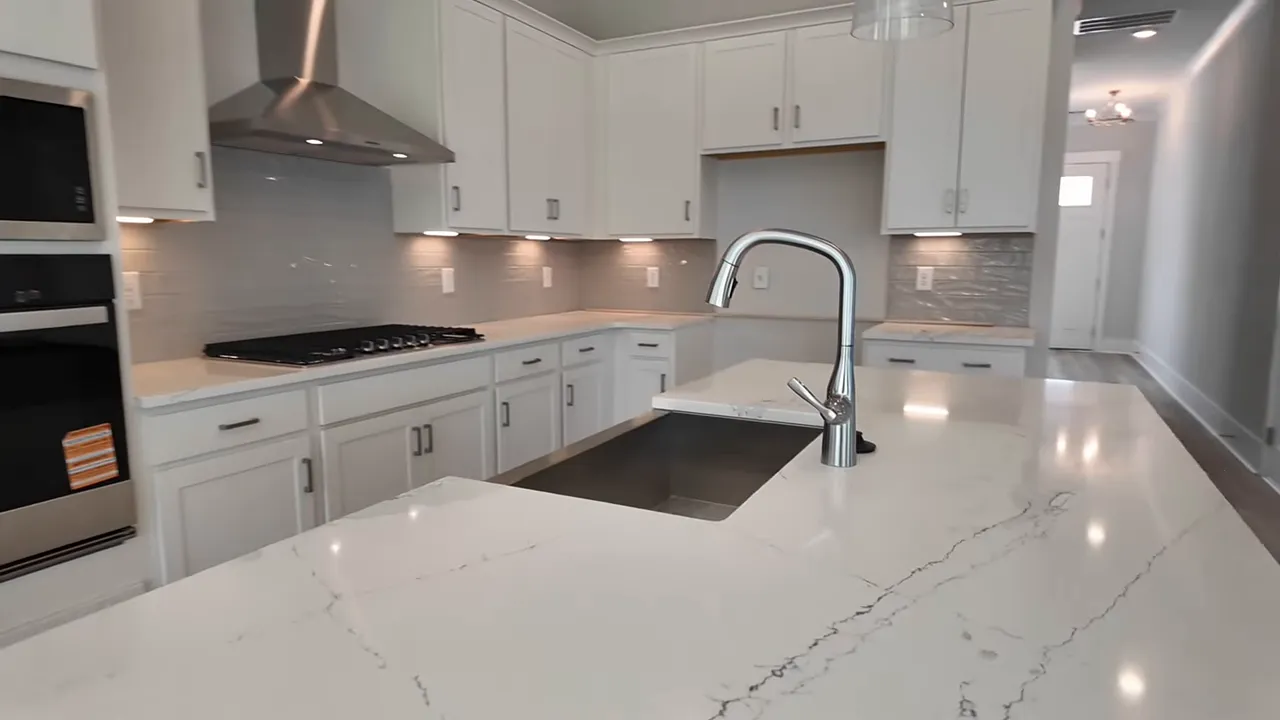 White kitchen with quartz island stainless sink and white cabinets