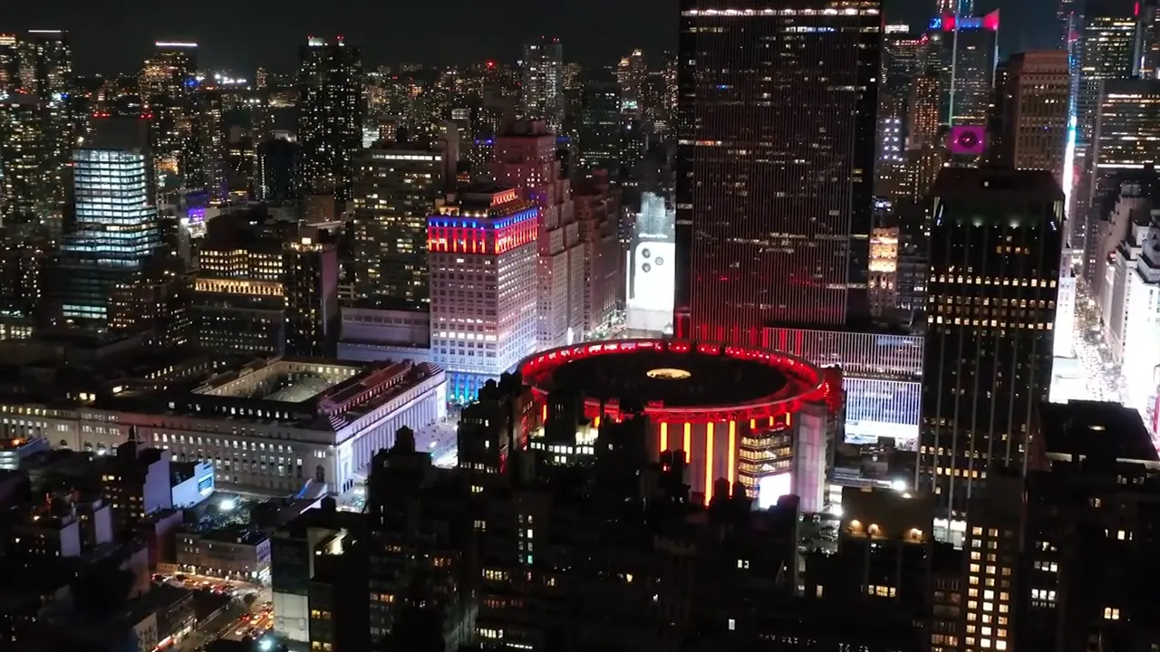 Nighttime aerial view of New York City skyline with brightly lit buildings