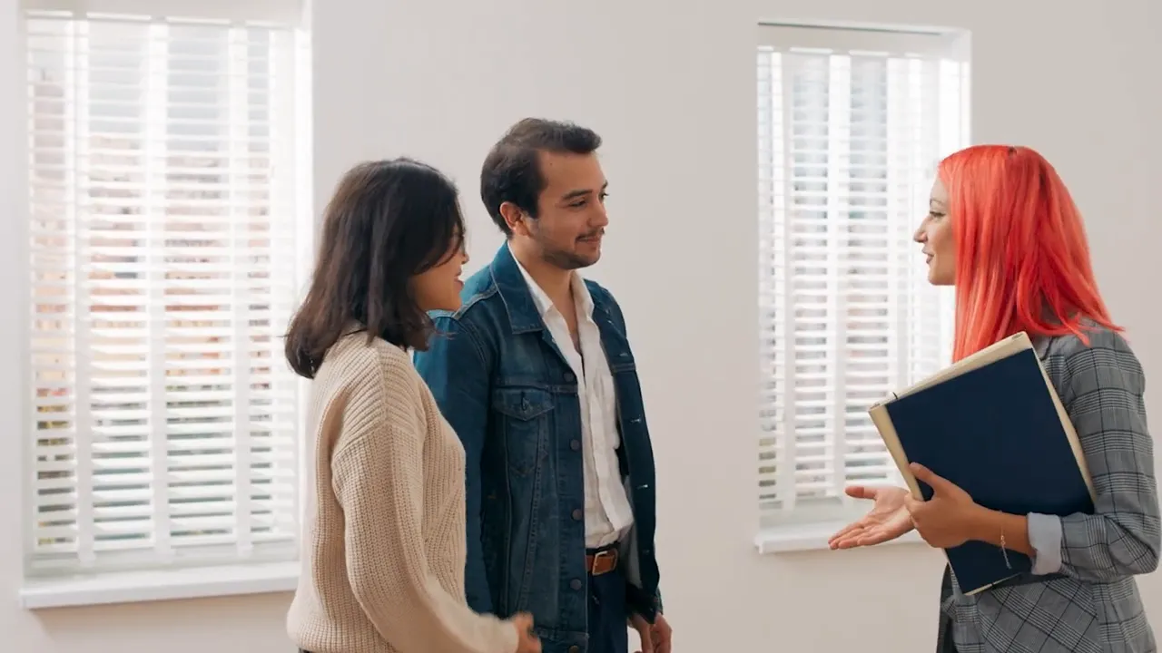Real estate agent and home buyers standing during a property showing