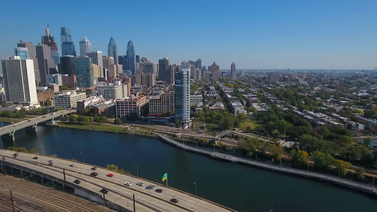 aerial view of Philadelphia skyline across the river with highway and bridge in foreground