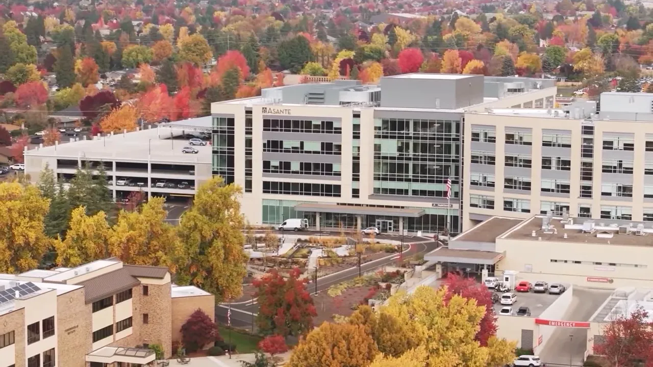 Large hospital building surrounded by autumn trees