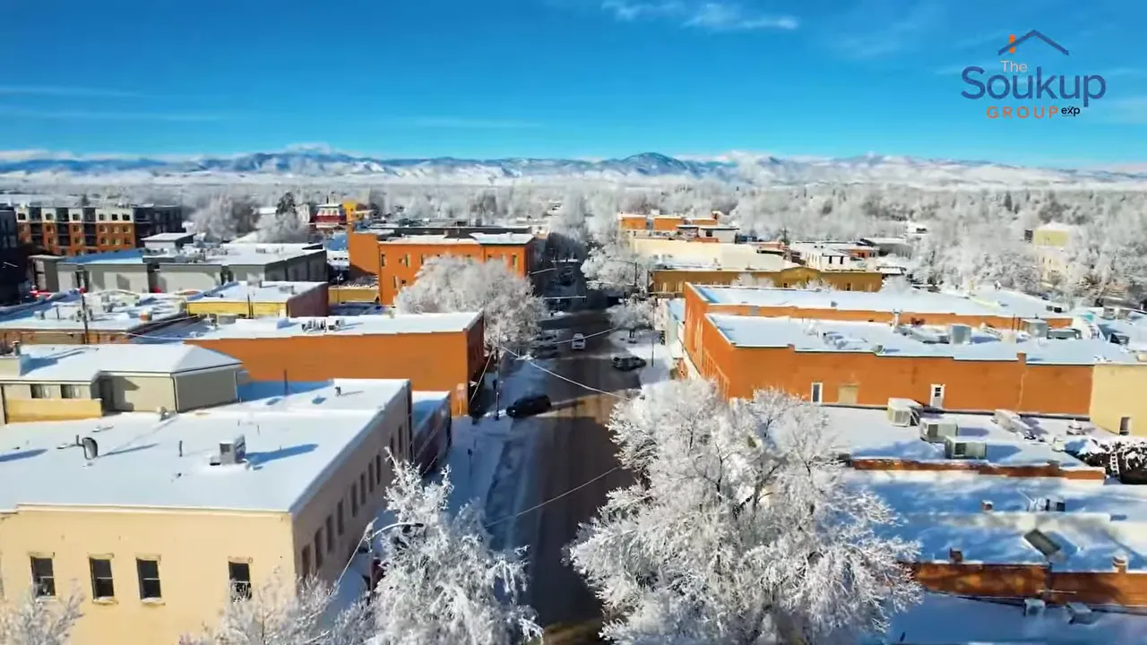 Snow-covered downtown buildings beneath a clear blue sky