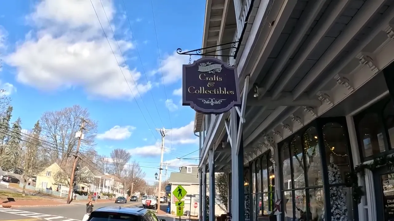Street view of storefronts and hanging shop sign in Chester style downtown area