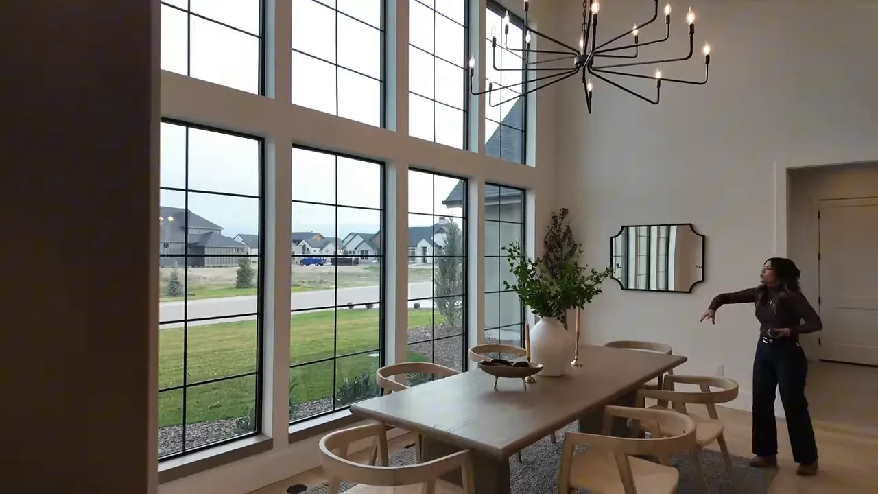 Luxury dining space in a Boise River home with tall arched windows and chandelier lighting
