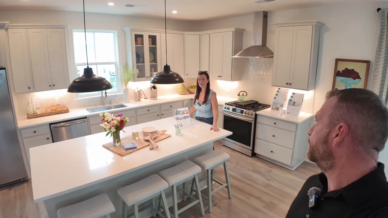 Wake model home kitchen with spacious island, pendant lights, and stainless appliances