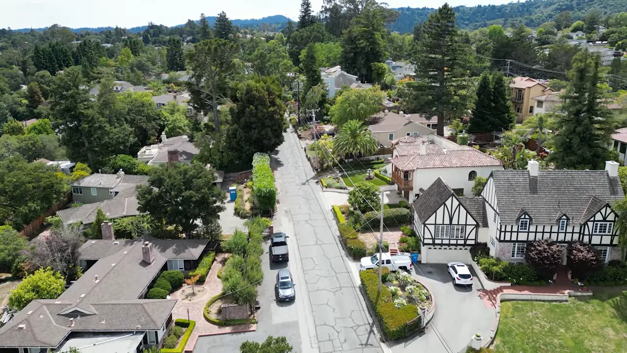 clear drone aerial of a residential street and surrounding homes in San Mateo County