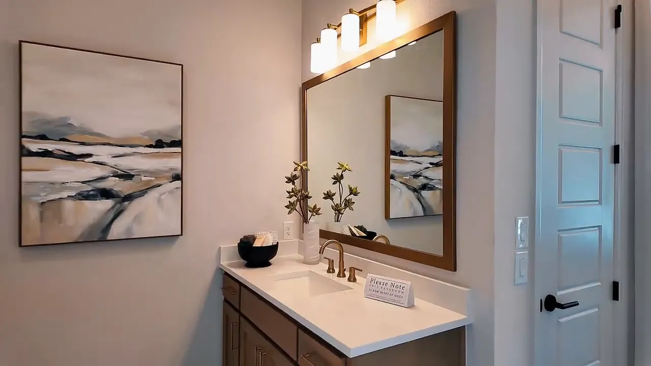 Primary bathroom vanity with mirrors and modern lighting in Meraki by Perry Homes home in Forney, Texas