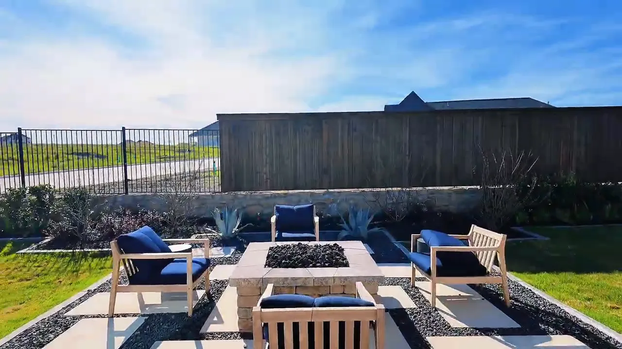 Outdoor patio with fire pit area, seating chairs, and paver patio in Meraki by Perry Homes Forney Texas backyard