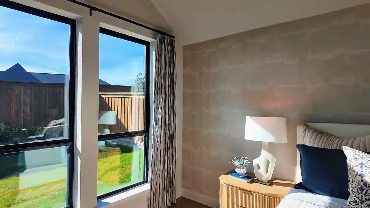 Primary bedroom view with large windows and natural light