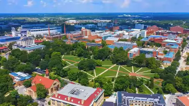 Aerial view of a college campus with green lawns and red brick buildings