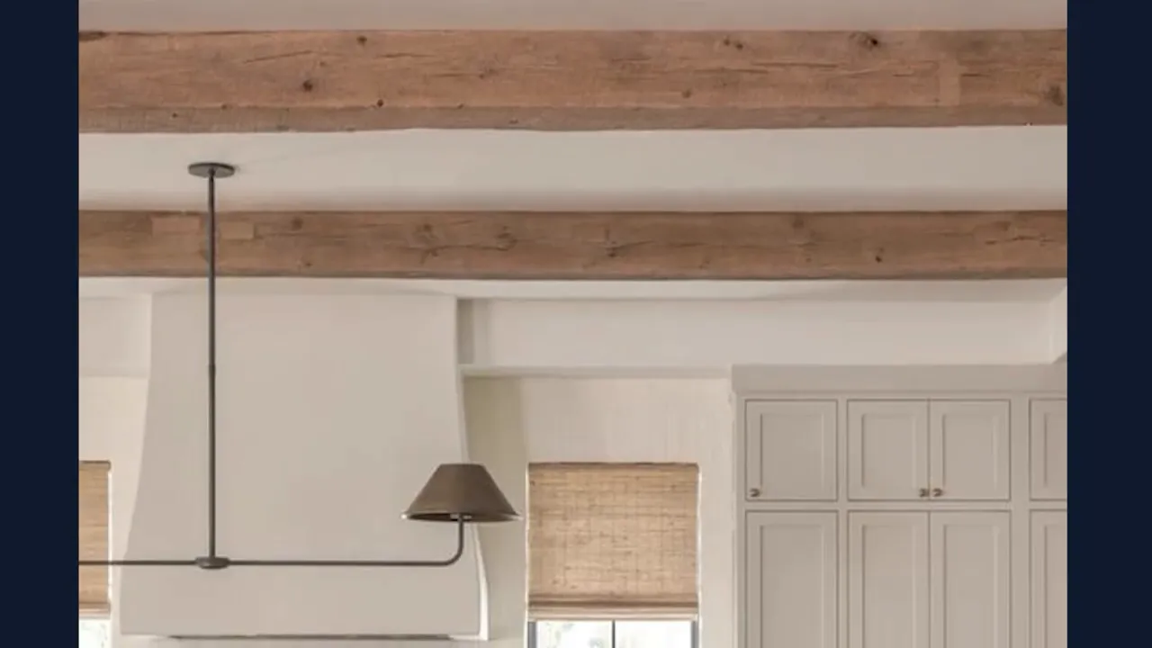New construction living room with modern black pendant light, warm wood ceiling beams, and paneled millwork