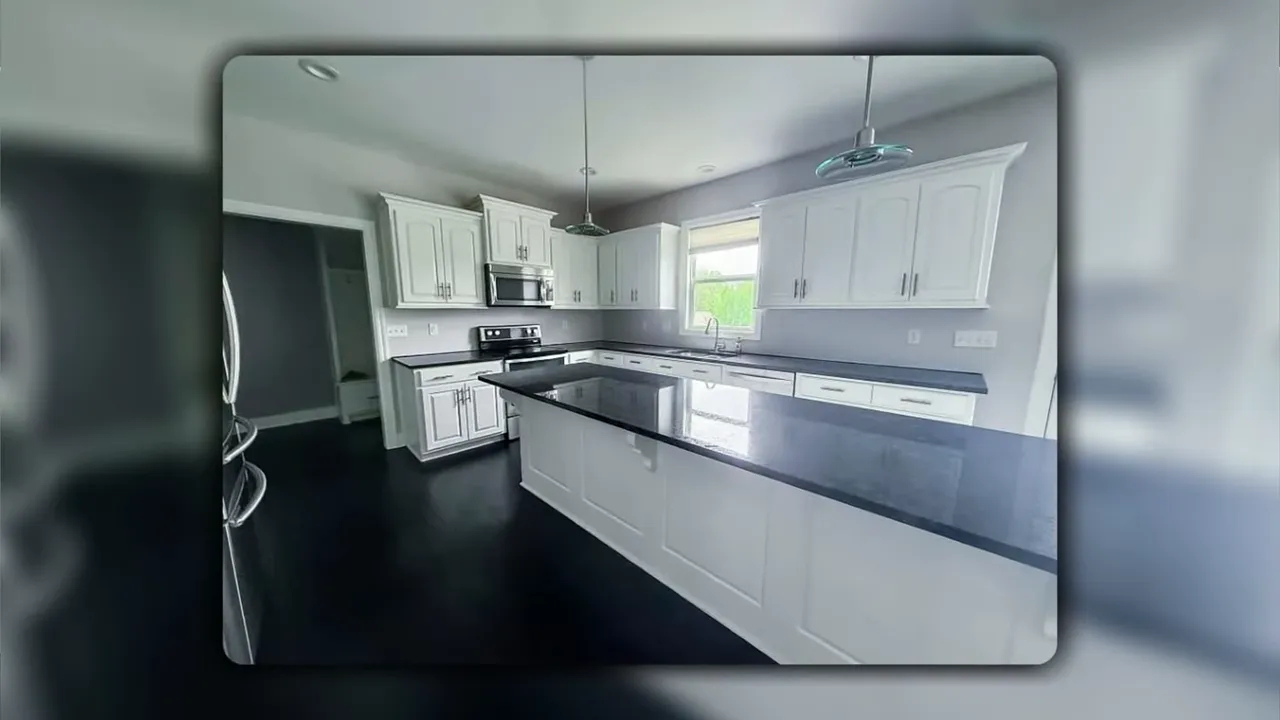 Kitchen with white cabinets and dark countertops in Hidden Pines home at 708 Clubhouse Drive