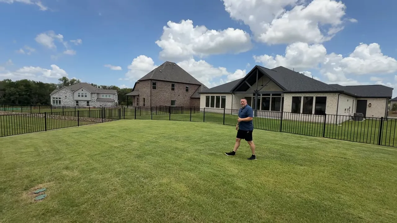 Expansive backyard at Heath Golf and Yacht Club with open lawn and wrought-iron fence