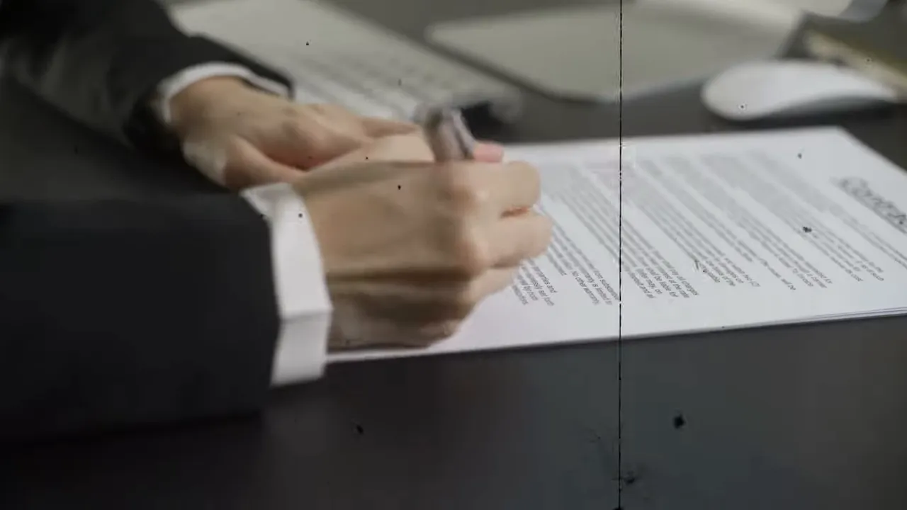 Close-up of hands reviewing printed contract documents on a desk