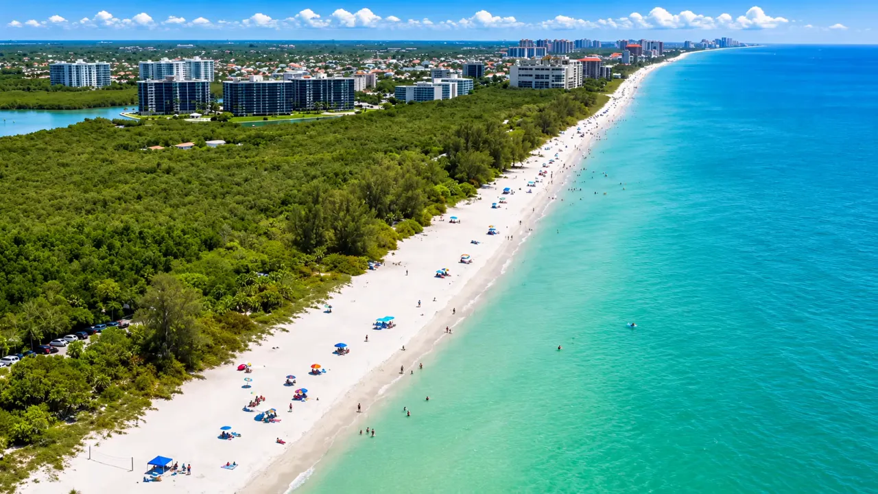 Aerial view of a long sandy beach beside turquoise Gulf water and coastal vegetation