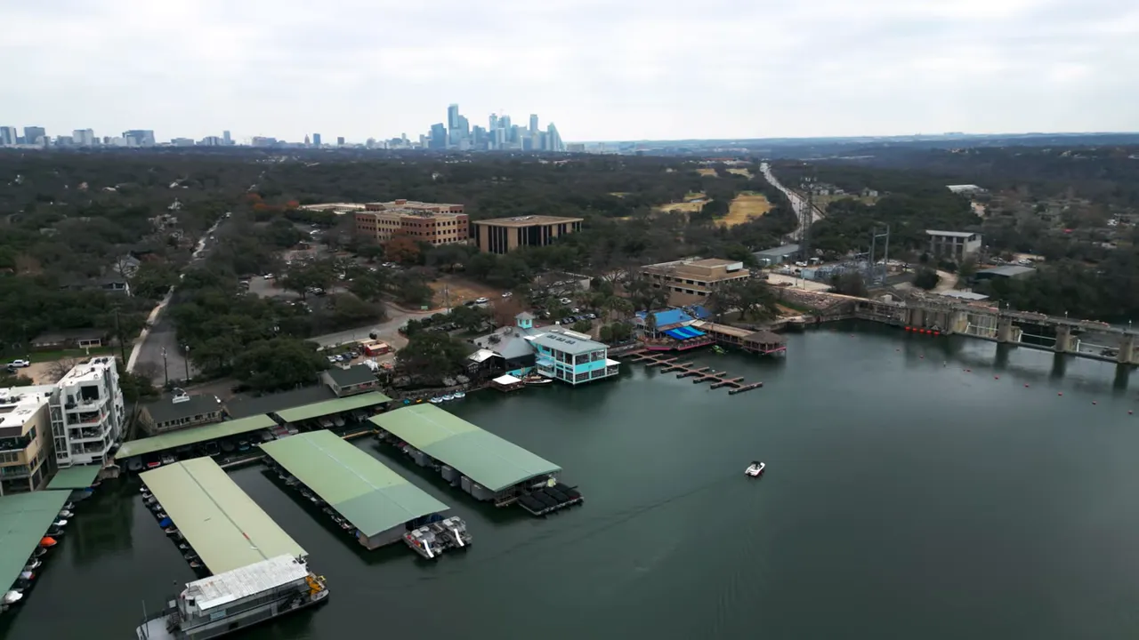 Aerial landscape view of Lake Austin waterfront and nearby neighborhood areas with city skyline