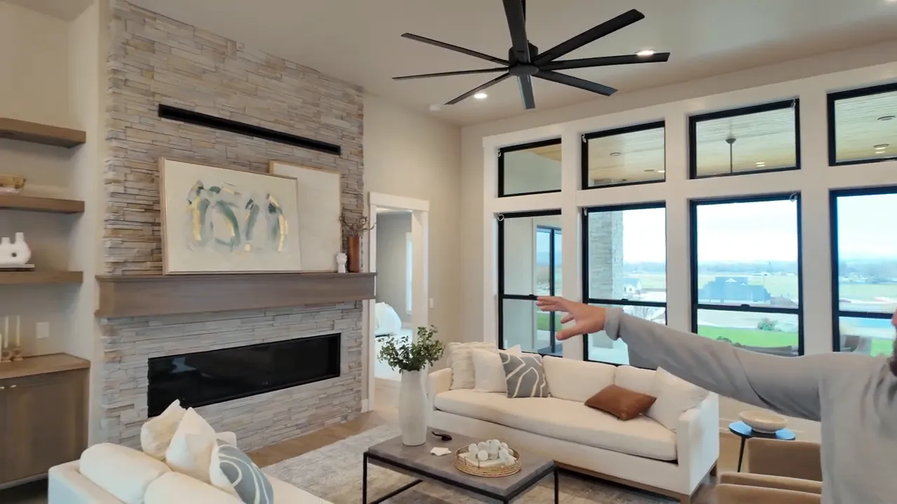 Living room with tall ceilings stone fireplace and large black framed windows