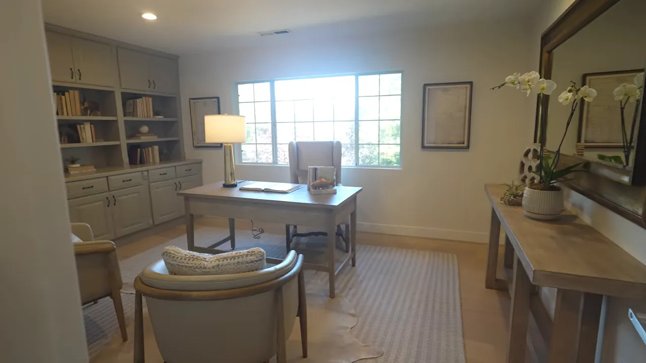 Office with desk chairs built in shelving and window