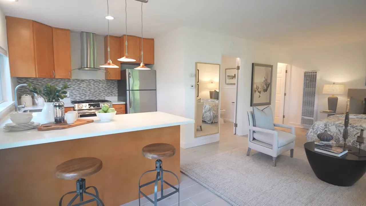 Studio ADU interior with kitchen peninsula stools bed and bathroom door