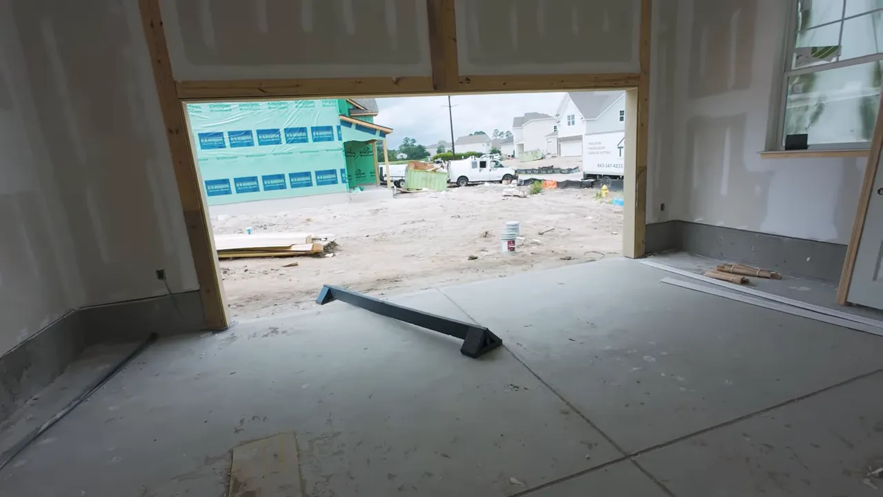 New construction garage-facing interior view with unfinished walls and concrete slab