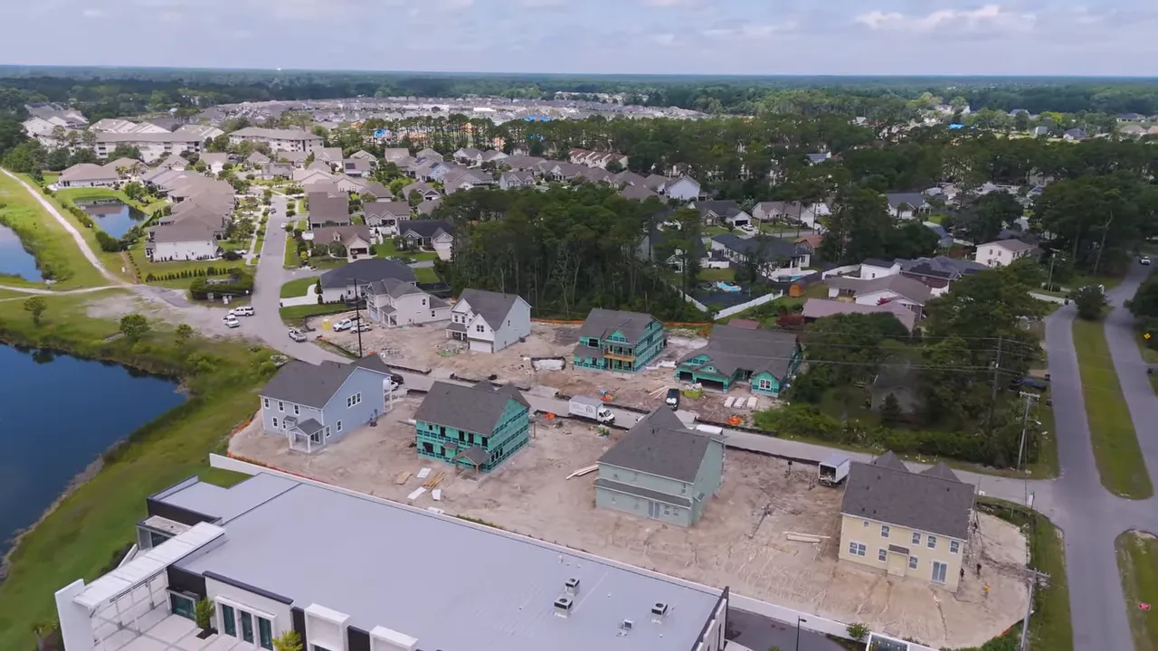 Aerial view of new construction homes in North Myrtle Beach community with pond and limited 11-home release