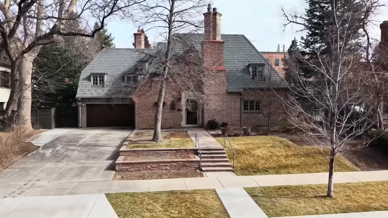 Brick luxury estate exterior with driveway and landscaped front yard