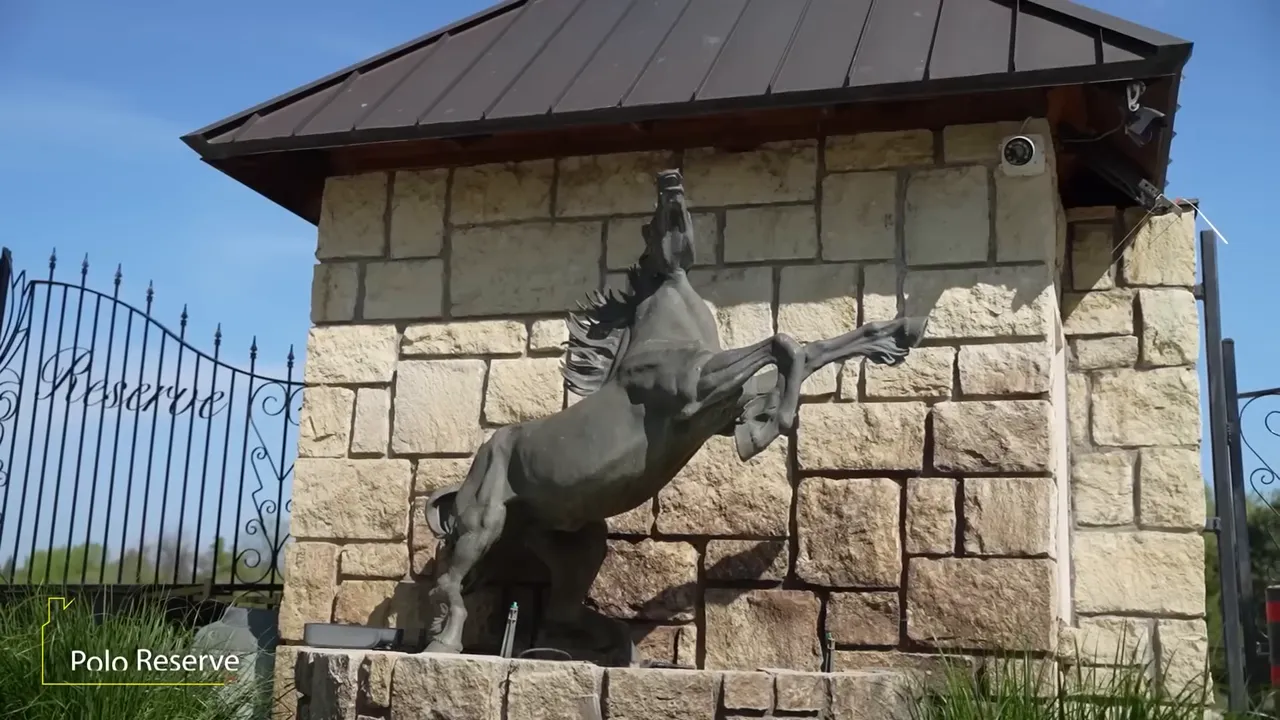 Polo Reserve entry monument with a polo player statue in front of stone walls