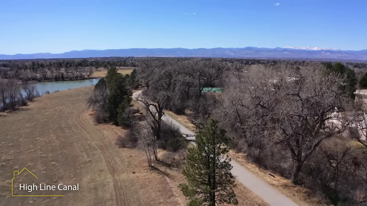 Aerial view of the High Line Canal corridor with surrounding open fields, trees, and mountain backdrop