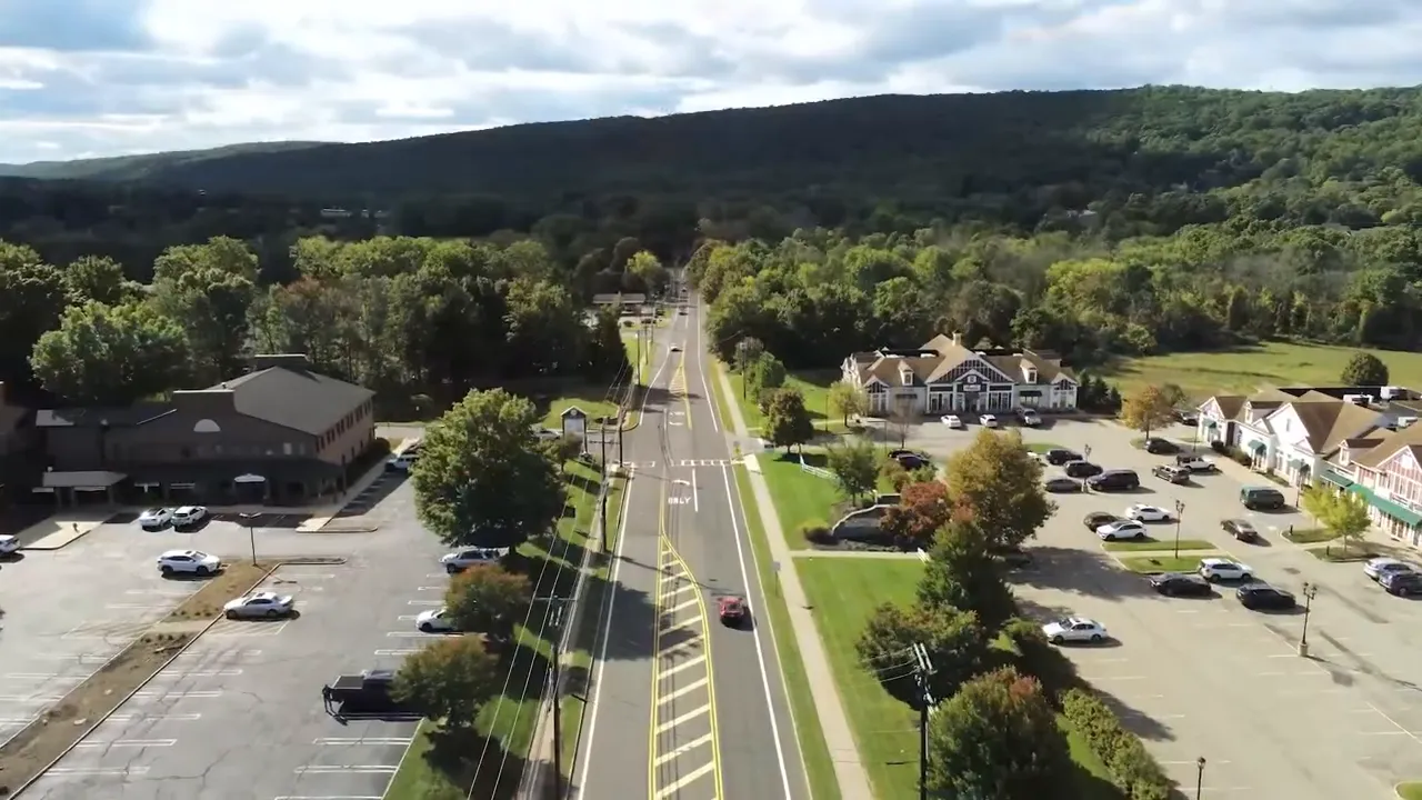 Aerial view of divided roadway with shopping areas and parking lots on both sides