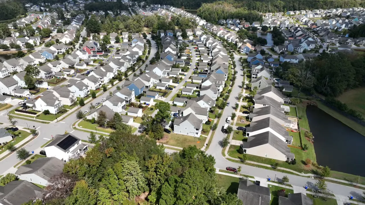 Aerial view of a Summerville suburban neighborhood with rows of single-family homes and a pond