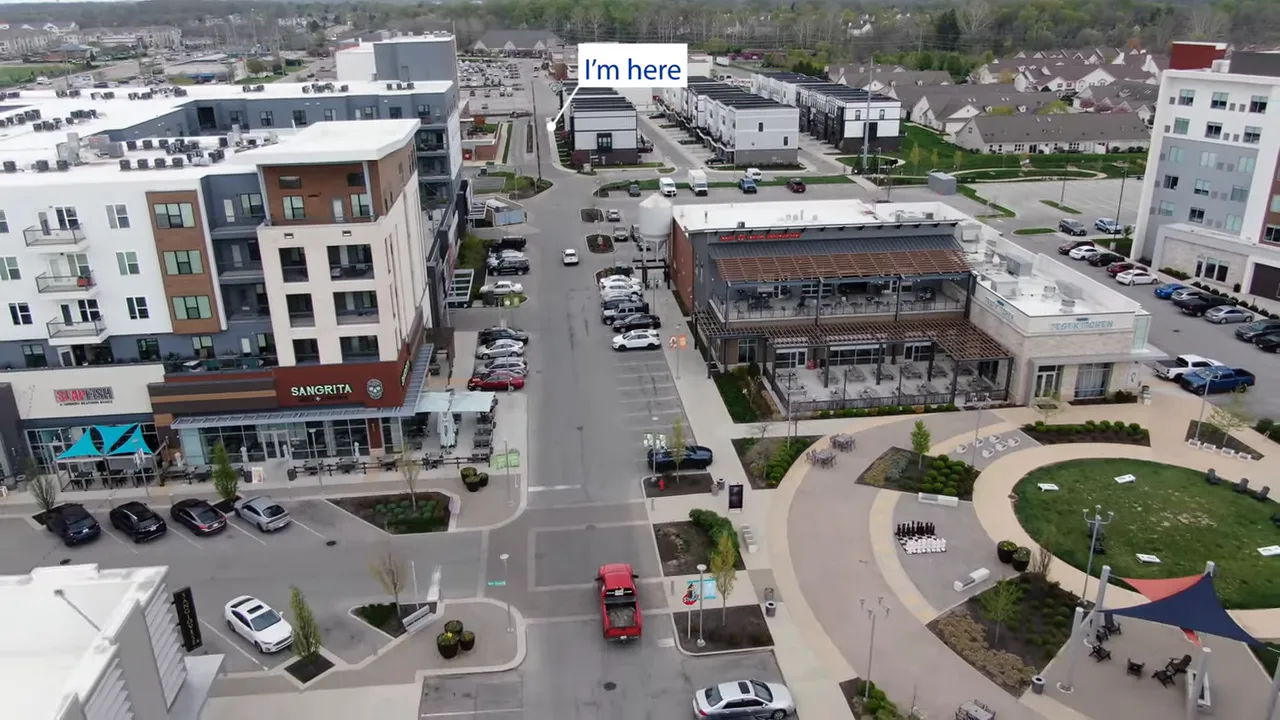 Aerial view of dense mixed use district with label saying Im here above nearby streets and buildings
