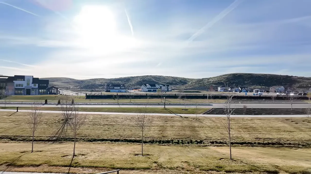 Wide view of Valnova Subdivision streetscape with open green space and rolling hills