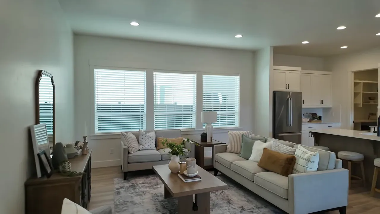 Bright living room with sectional seating and large windows in Valnova subdivision home