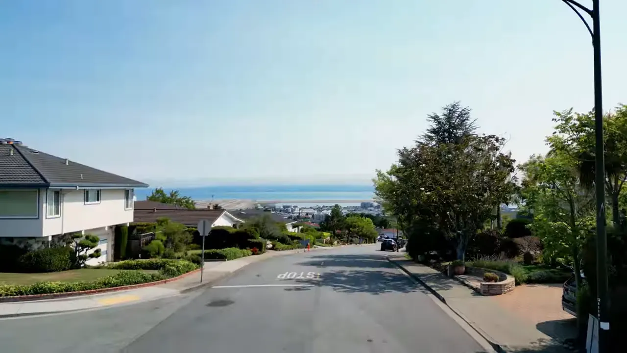 Hillside residential street in Mills Estates with bay views in the distance