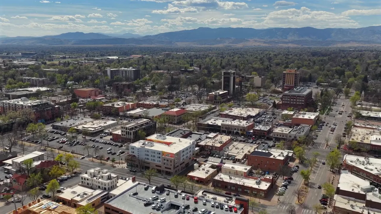 Aerial view of an established city with streets buildings and mountains in the distance