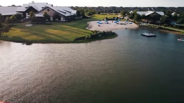 Aerial view of homes around a lake with boats and a sandy recreation area