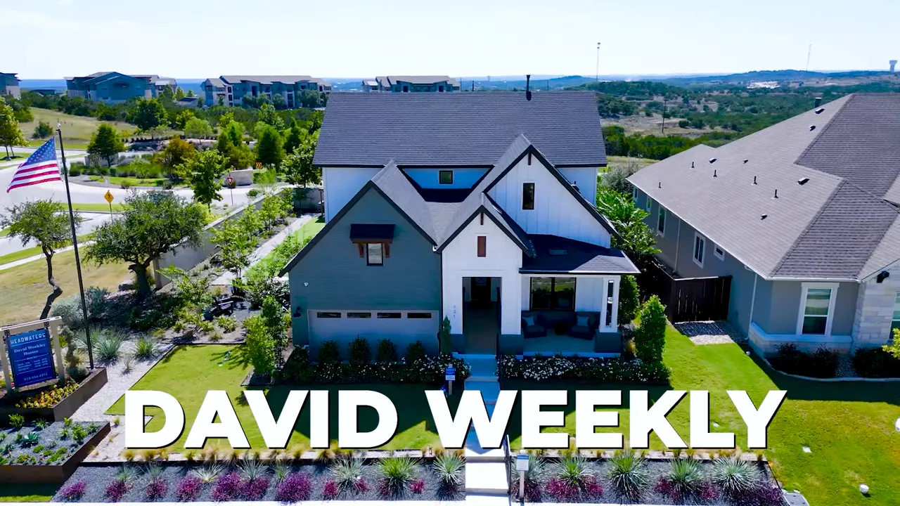 Frontal drone shot of a David Weekley model home at Headwaters with landscaped front yard and prominent DAVID WEEKLY text overlay