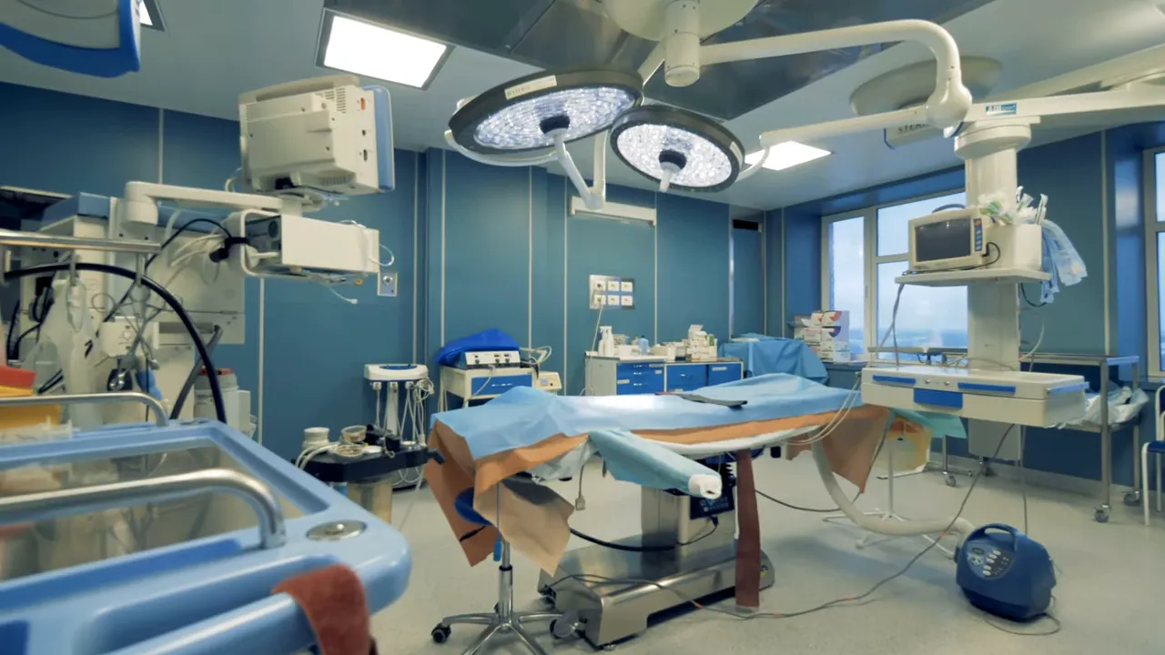 Operating room with surgical lights, equipment, and an empty operating table