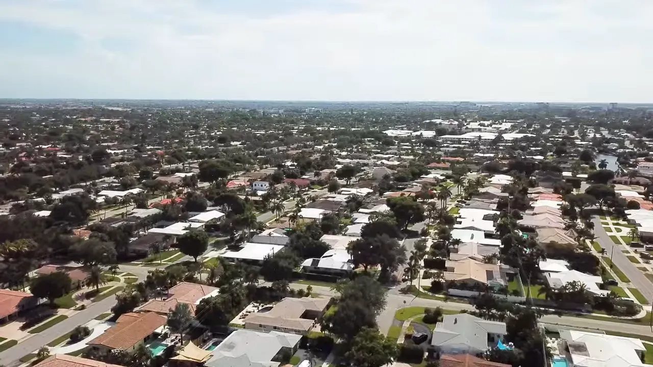Aerial drone view of Imperial Point, Fort Lauderdale showing single-story homes, streets, yards and pools.